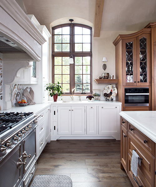 Luxury kitchen remodel designed by William Ohs in Denver featuring custom cabinetry in medium-colored wood and white wood