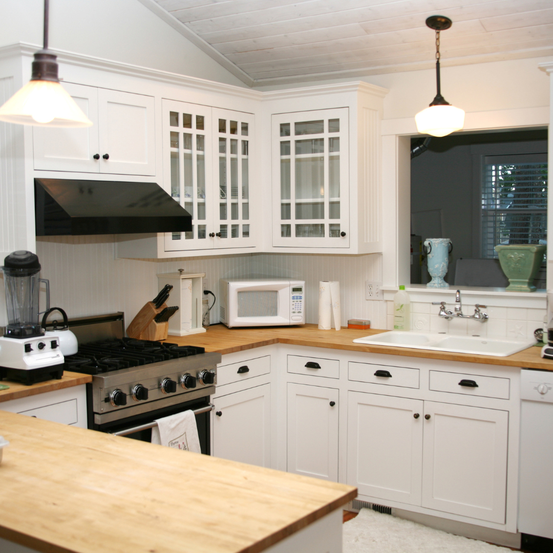 kitchen with butcher block counter and white cabinets