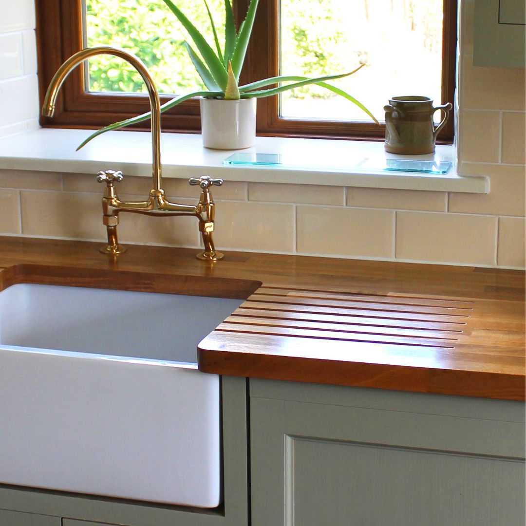 kitchen sink with wood counter and green cabinets