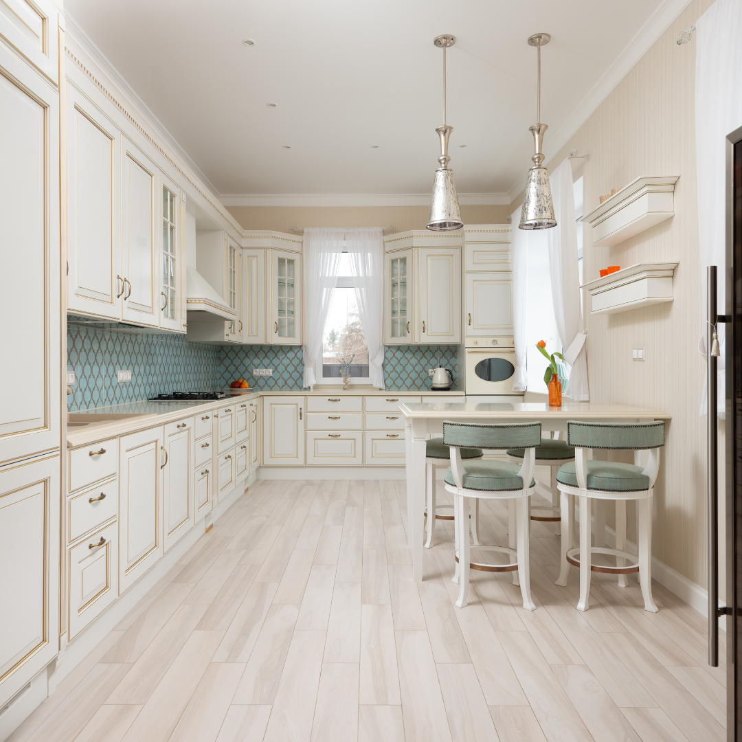A kitchen with white cabinets with gold accents